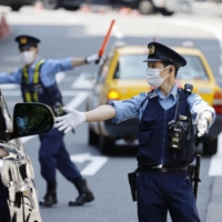 Police officers check vehicles near the U.S. Embassy in Tokyo on Thursday ahead of a visit by U.S. President Joe Biden\'s from Sunday. | KYODO