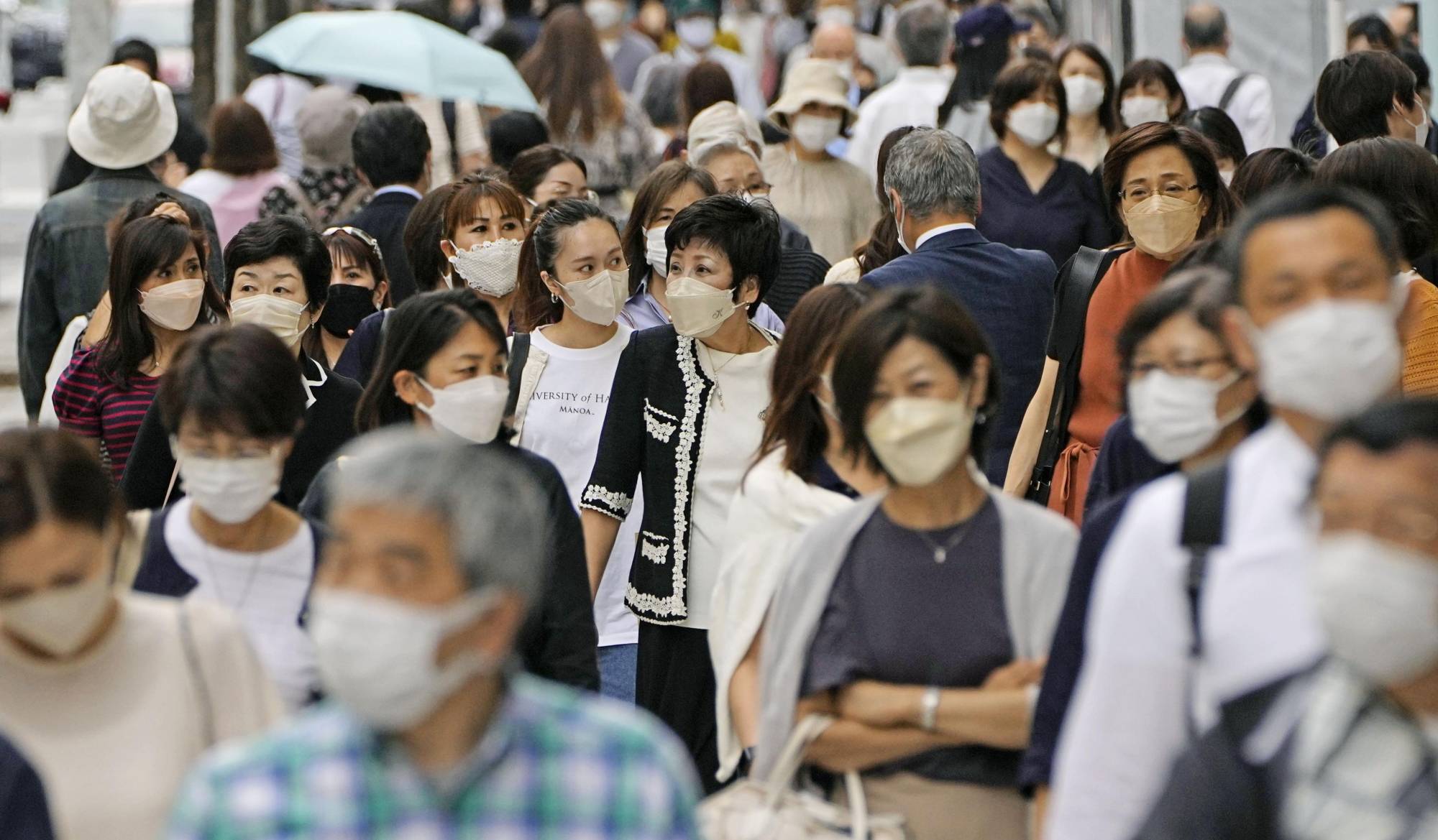Officials say it is acceptable to take off masks outside, even when standing close to another individual, as long as there’s no chatting involved, with the government clarifying its stance on the issue for the first time. | KYODO