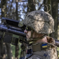 A Ukrainian soldier carries a U.S.-made Stinger missile launcher at a short-range artillery position in the Kherson region of southern Ukraine on May 6. | DAVID GUTTENFELDER / THE NEW YORK TIMES
