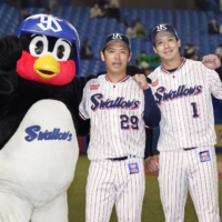 The Swallows\' Tetsuto Yamada (right) and Yasuhiro Ogawa pose with the team mascot after their win over the Tigers on Thursday at Jingu Stadium. | KYODO