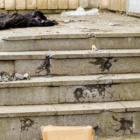 Bullet holes pockmark steps and a wall near the bodies of men executed in the courtyard of 144 Yablunska St. in Bucha, Ukraine. | BENJAMIN FOLEY/THE NEW YORK TIMES