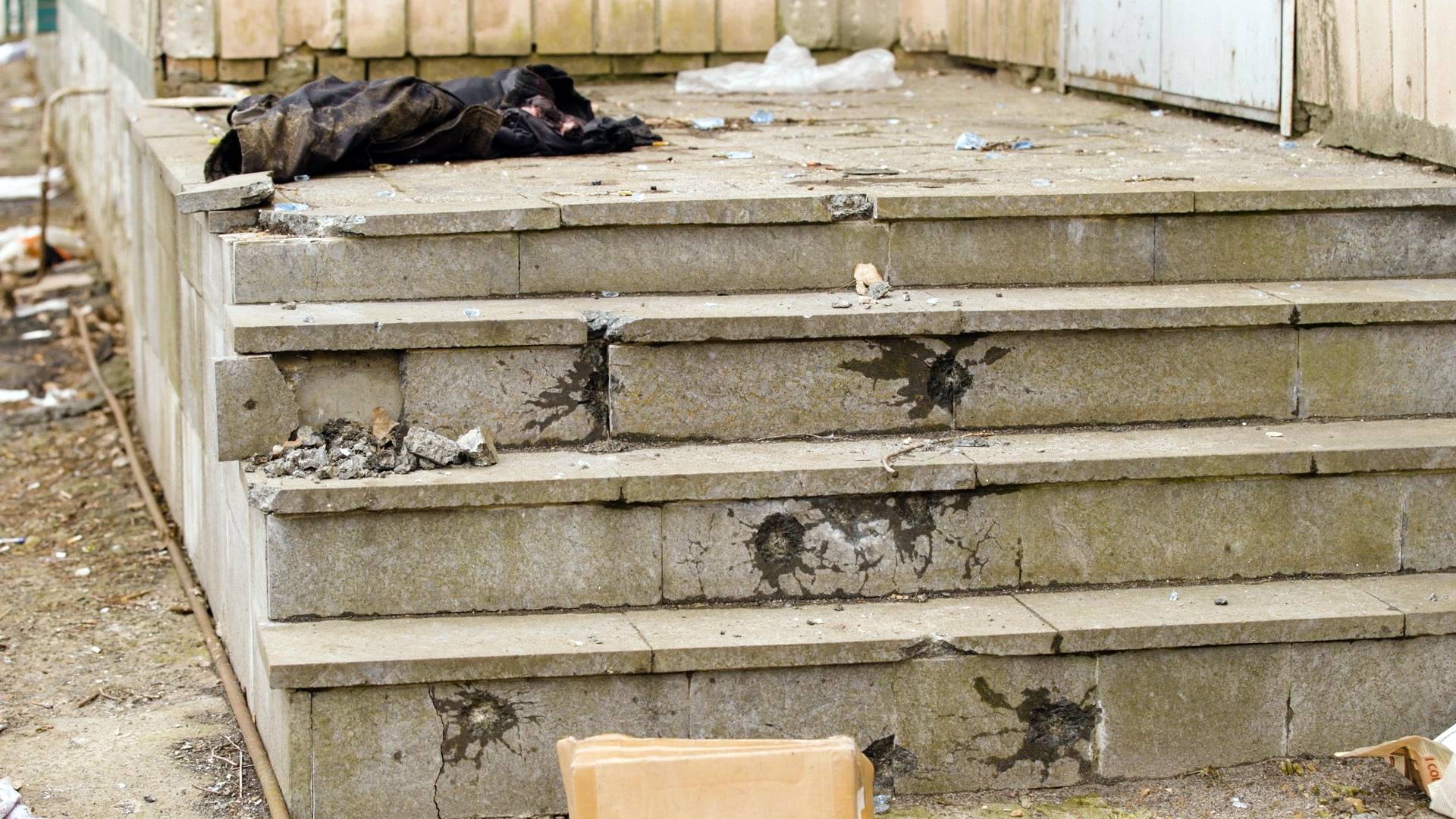 Bullet holes pockmark steps and a wall near the bodies of men executed in the courtyard of 144 Yablunska St. in Bucha, Ukraine. | Benjamin Foley/The New York Times