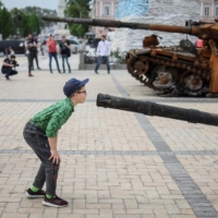 A boy looks at a destroyed Russian infantry fighting vehicle during an exhibition displaying destroyed Russian military vehicles in central Kyiv on Saturday. | REUTERS