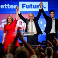 Anthony Albanese, Australia\'s next prime minister, is accompanied by his partner, Jodie Haydon, and his son Nathan Albanese, as he celebrates his victory on Saturday. | REUTERS
