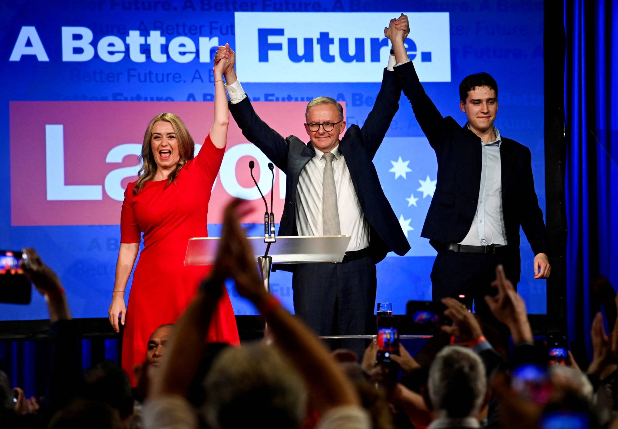 Anthony Albanese, Australia's next prime minister, is accompanied by his partner, Jodie Haydon, and his son Nathan Albanese, as he celebrates his victory on Saturday. | REUTERS
