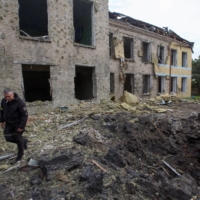 A police officer walks next to a school building damaged by a Russian military strike in the settlement of Kostiantynivka, in Donetsk region, Ukraine, on Sunday. | REUTERS