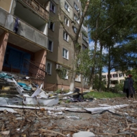 A local woman looks at an apartment building damaged by a Russian military strike in the town of Vuhledar, in Donetsk region, Ukraine, on Sunday. | REUTERS
