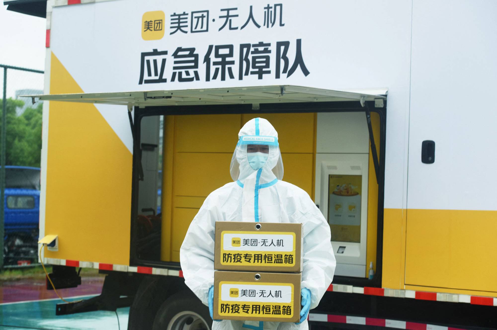A staff member carries boxes containing samples to be tested for COVID-19 at a testing facility in Hangzhou, China. | AFP-JIJI