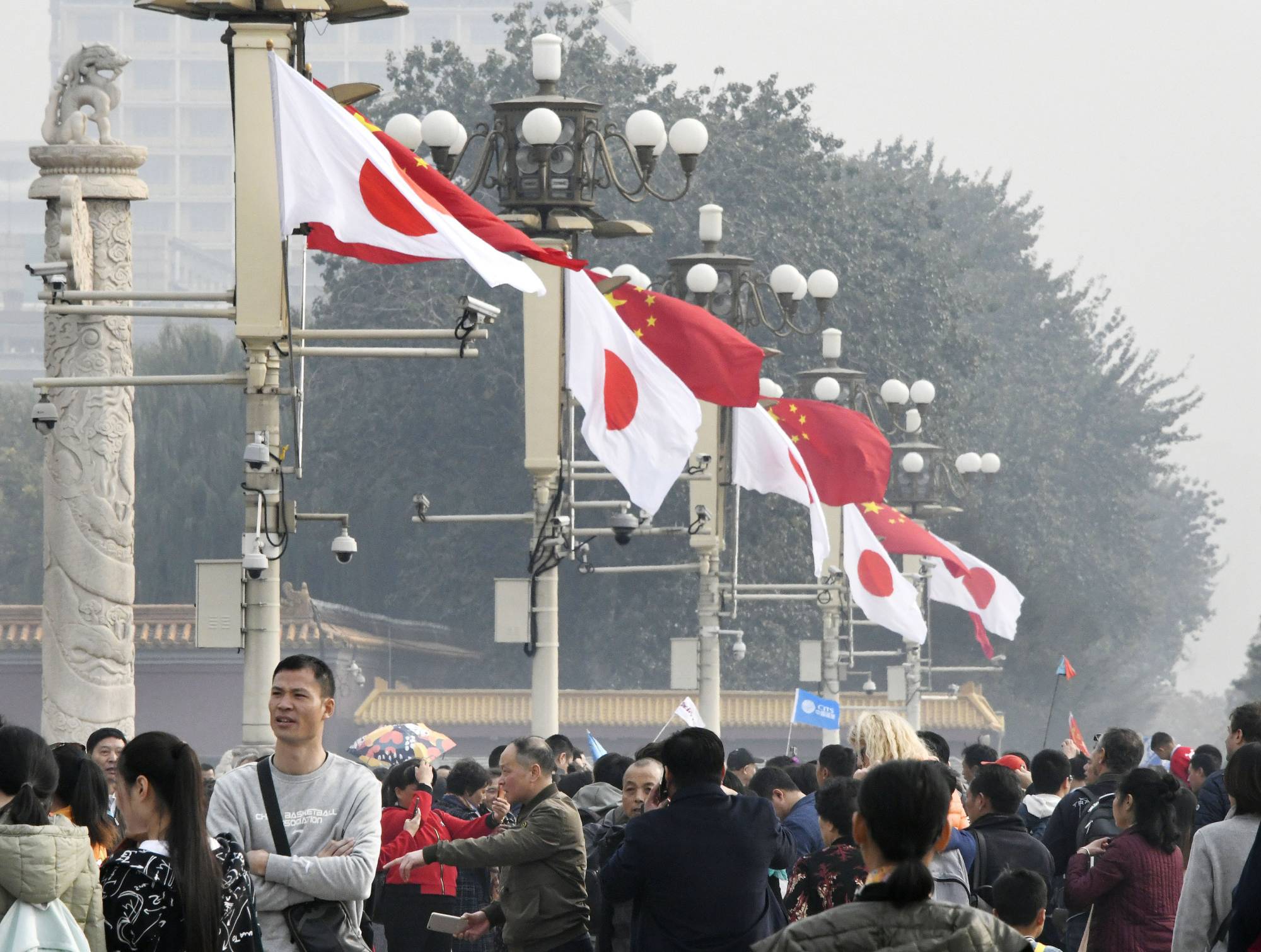 Japanese and Chinese national flags fly in Tiananmen Square in Beijing in October 2018, ahead of a visit to China by then-Prime Minister Shinzo Abe. | KYODO