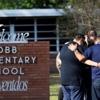 Residents gather at Robb Elementary School, the scene of a mass shooting, in Uvalde, Texas, on Wednesday. | REUTERS