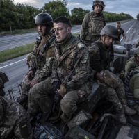 Ukrainian soldiers from the 95th Air Assault Brigade load onto an armored vehicle as they head toward the frontline near the city of Kramatorsk in Ukraine’s eastern Donetsk region, on Wednesday. Ukrainian officials say Russia is likely to resort to siege tactics as it tries to encircle and capture Sievierodonetsk and other cities in the Donbas region.  | FINBARR O\'REILLY / THE NEW YORK TIMES