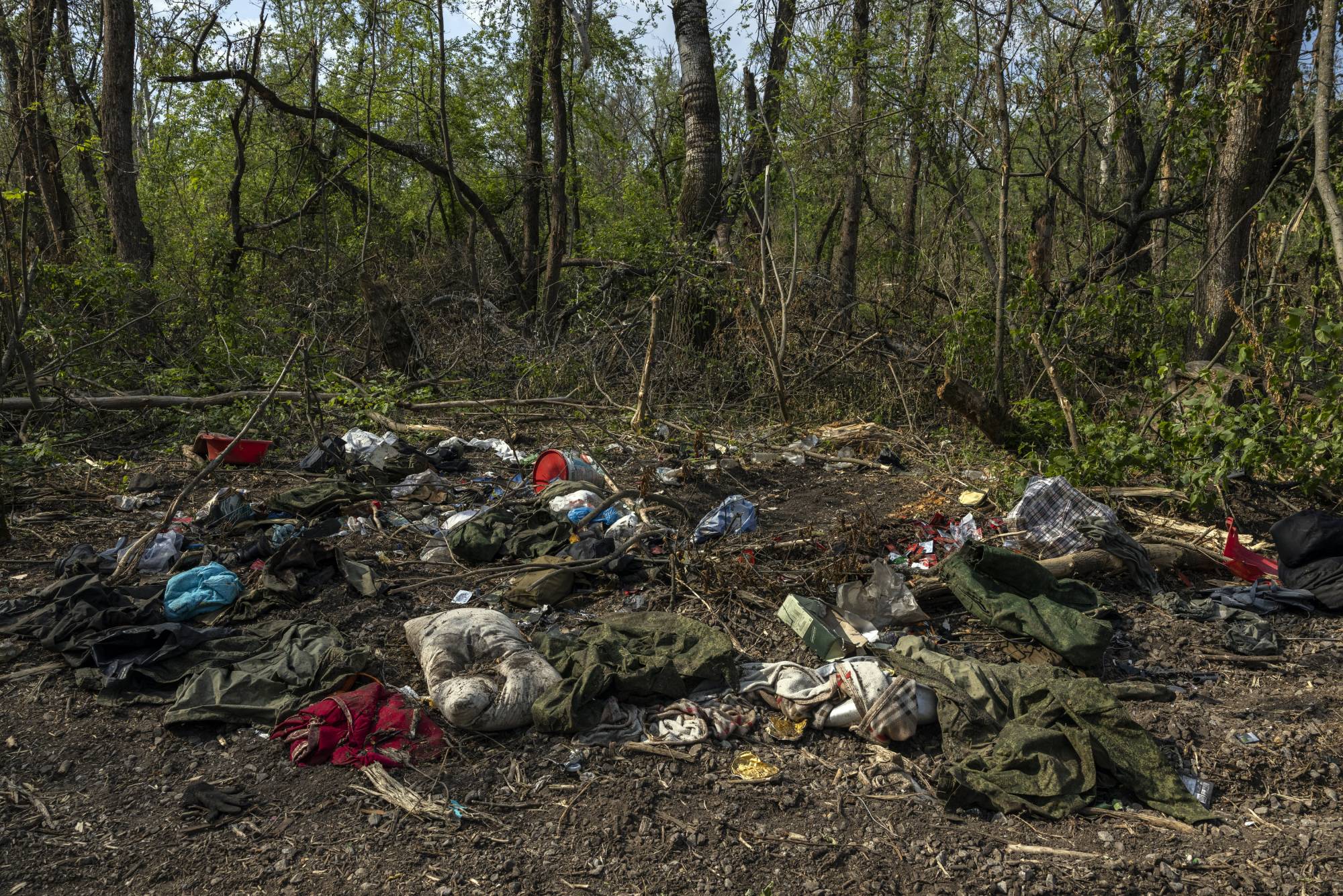 Discarded and abandoned Russian military uniforms and other personal belongings lay not far from the Seversky Donets River near Sievierodonetsk, Ukraine, on Wednesday. | Ivor Prickett / The New York Times