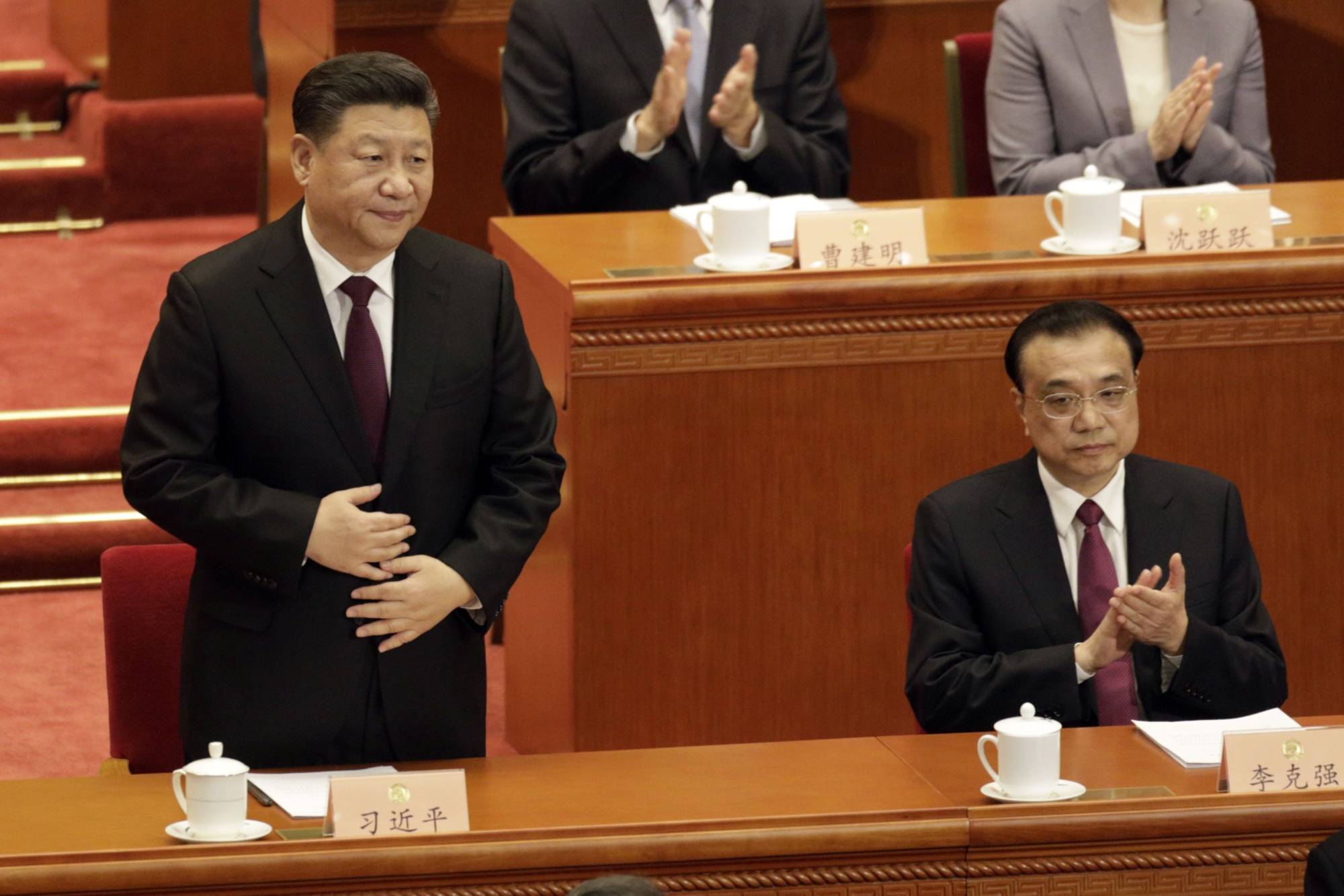 Chinese President Xi Jinping (left) and Chinese Premier Li Keqiang at the Great Hall of the People in Beijing in March 2019. Many government officials charged with implementing policy at the ground level aren’t quite sure who to listen to: Xi and his push for zero COVID-19 cases, or Li's calls to bolster the economy. | BLOOMBERG