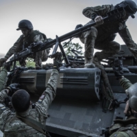 Ukrainian soldiers from the 95th Air Assault Brigade load a weapon onto an armored vehicle near the city of Kramatorsk, Ukraine, on Wednesday. | FINBARR O\'REILLY / THE NEW YORK TIMES