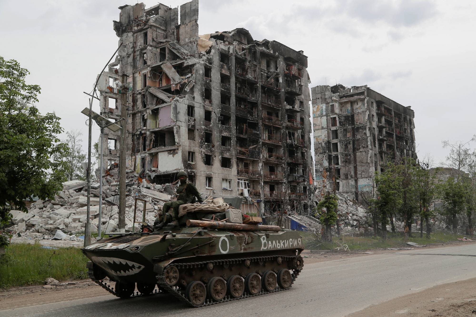 Service members of pro-Russian troops drive an armored vehicle in the town of Popasna in the Luhansk Region of Ukraine on Thursday. | REUTERS