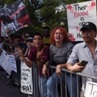 A crowd of protesters yells as people leave the National Rifle Association\'s annual convention in Houston on Friday, just days after a massacre at a Texas elementary school.  | REUTERS