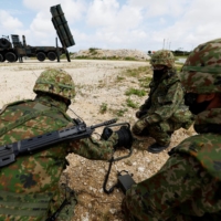 Members of the Ground Self-Defense Force conduct a drill next to an anti-ship missiles unit at Miyako Camp in Okinawa Prefecture in April.  | REUTERS