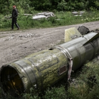 A man walks near the remains of a missile in the city of Lysychansk, in the eastern Ukrainian region of Donbas, on Thursday. | AFP-JIJI