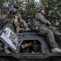 Ukrainian soldiers load onto an armored vehicle as they head toward the front line near the city of Kramatorsk in Ukraine’s eastern Donetsk region, on Wednesday.  | FINBARR O\'REILLY / THE NEW YORK TIMES