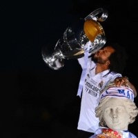Real Madrid\'s Marcelo kisses the Champions League trophy while on the statue of the Greek goddess Cybele in Madrid on Sunday. | AFP-JIJI