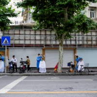 Residents get haircuts on a street in Shanghai on Monday. | REUTERS