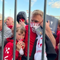 Liverpool supporters react after tear gas is deployed outside Stade de France before the Champions League final in Paris on Saturday. | REUTERS