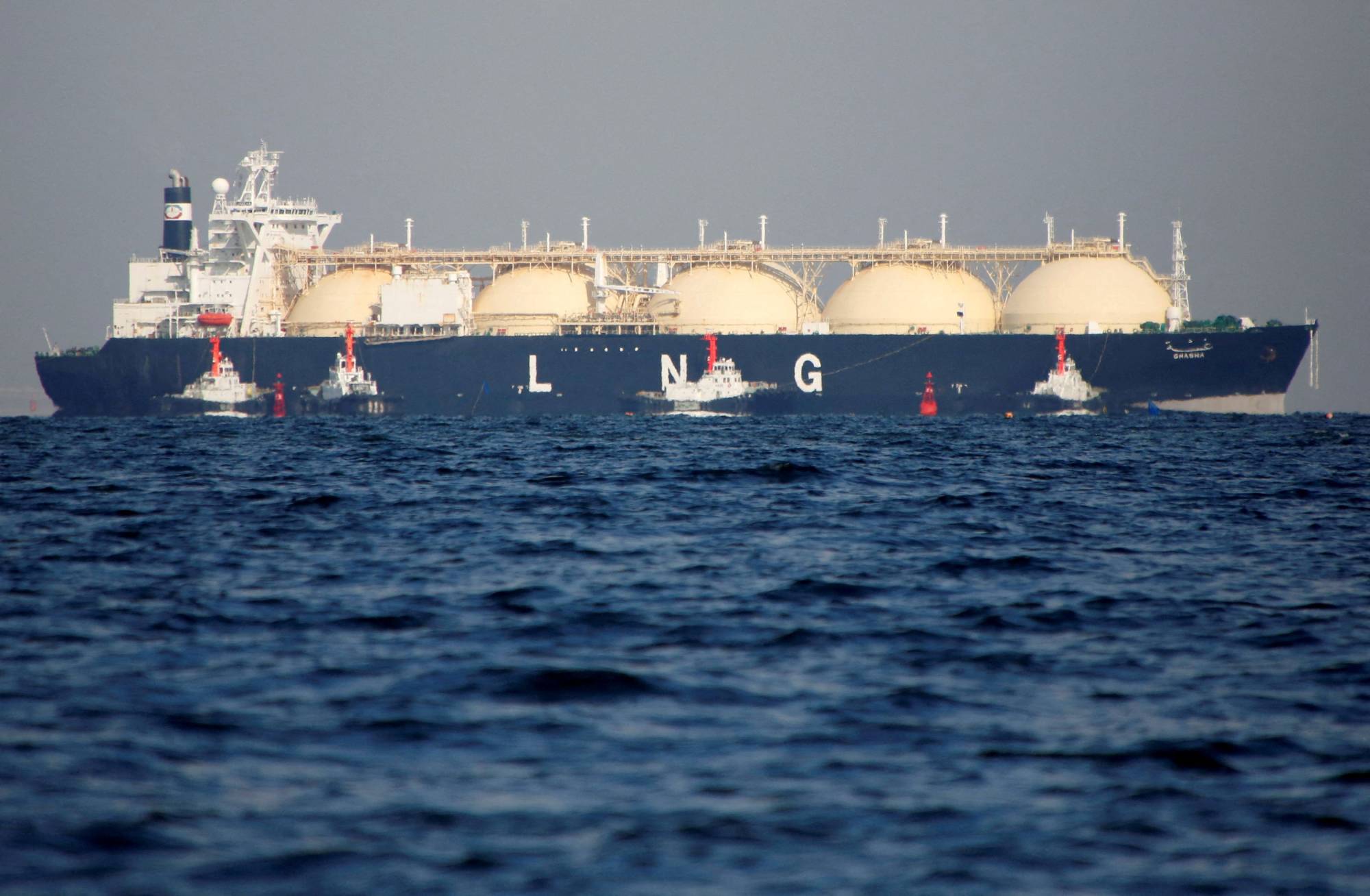 A liquefied natural gas tanker is tugged toward a thermal power station in Futtsu, Chiba Prefecture, in 2017. Parliament has passed an extra budget designed to assuage the impact of soaring prices for oil and other commodities. | REUTERS