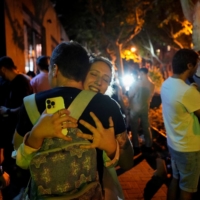 People hug on a street in Shanghai on Tuesday, as the city prepared to end a COVID-19 lockdown. | REUTERS
