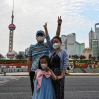 A family poses for a picture on The Bund in the Shanghai\'s Huangpu district Tuesday as the city prepared to lift a COVID-19 lockdown after two months of heavy-handed restrictions.  | AFP-JIJI