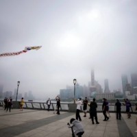 A man flies a kite to mark Children\'s Day on The Bund in Shanghai, after a COVID-19 lockdown was lifted Wednesday. | REUTERS