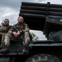Ukrainian soldiers sit atop a moving truck-mounted multiple rocket launcher near Lysychansk, eastern Ukraine on May 13. | AFP-JIJI