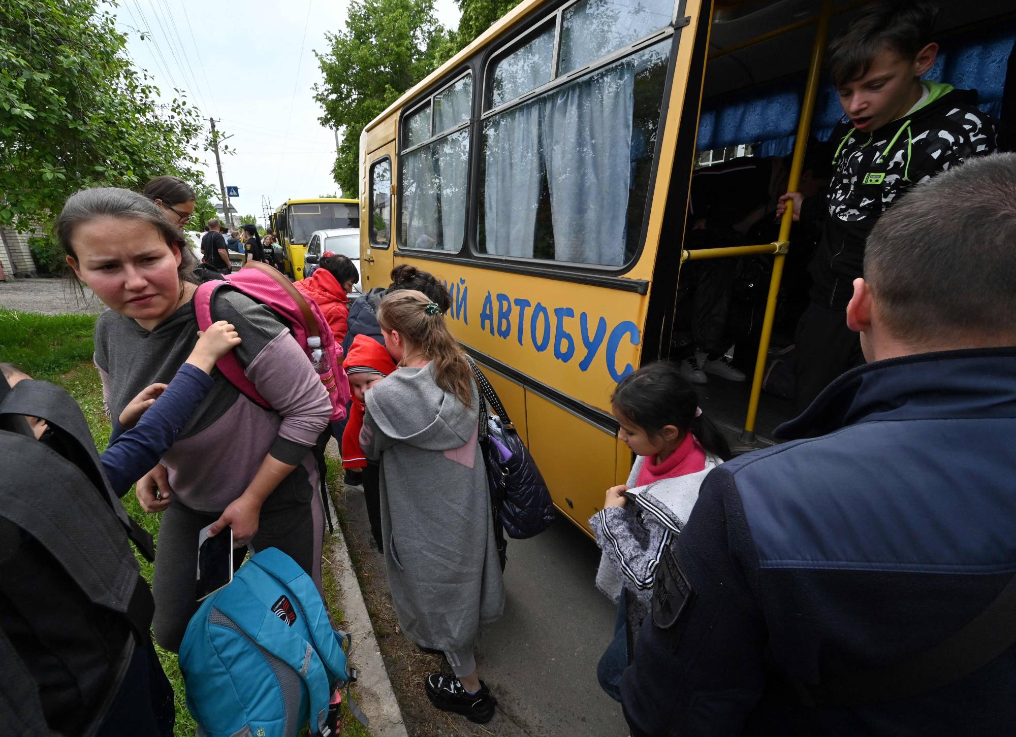 Evacuees exit a bus as they arrive in a small town east of Kharkiv, Ukraine, on Monday. | AFP-JIJI