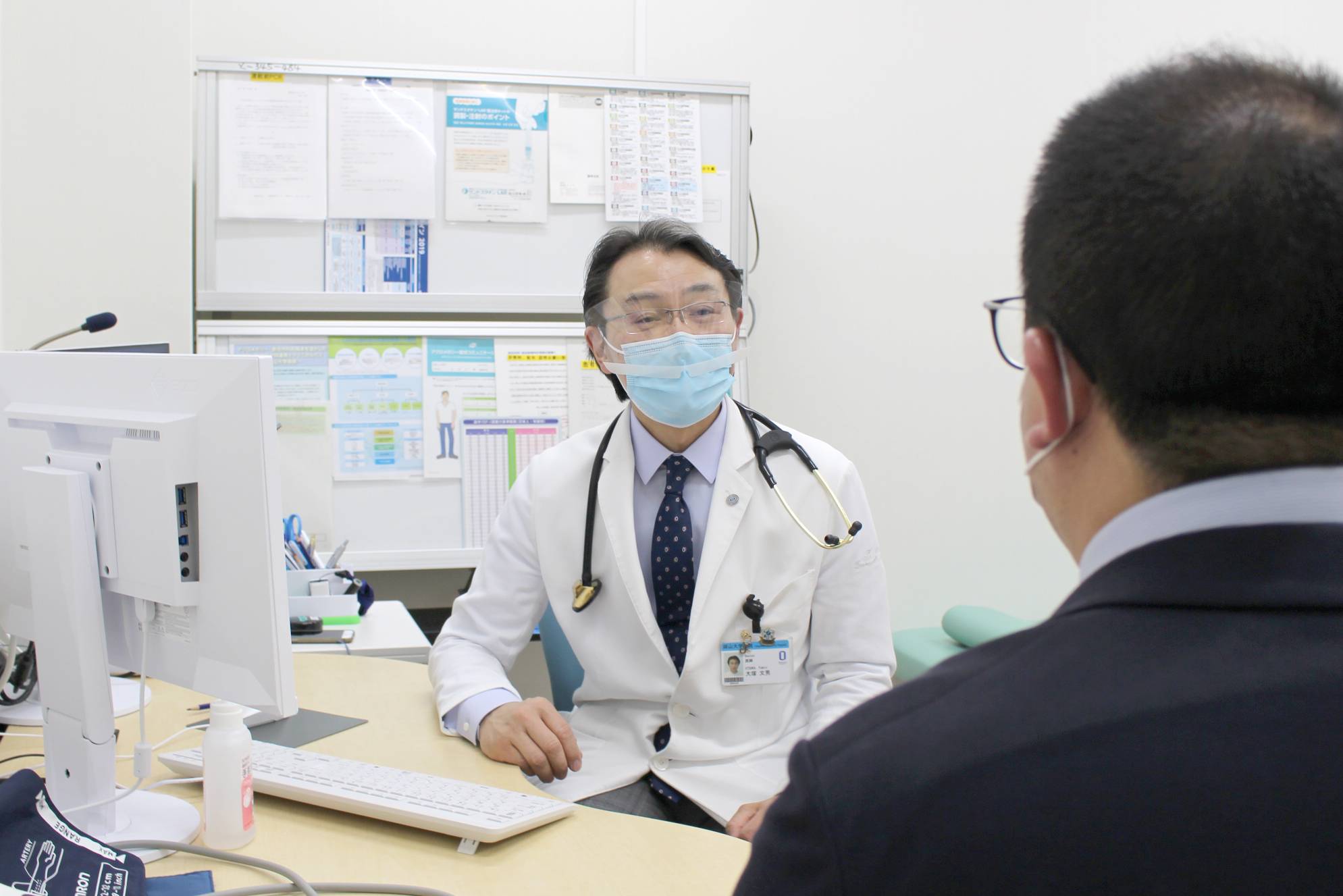 Fumio Otsuka, deputy director of Okayama University Hospital, speaks with a patient at the facility's COVID-19 aftercare clinic. | OKAYAMA UNIVERSITY HOSPITAL