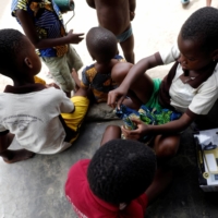 Children play beside a box of Salpha Energy solar panels at Sagbo-Kodji community, amid concerns over the spread of COVID-19, in Lagos, Nigeria, in April 2020. | REUTERS