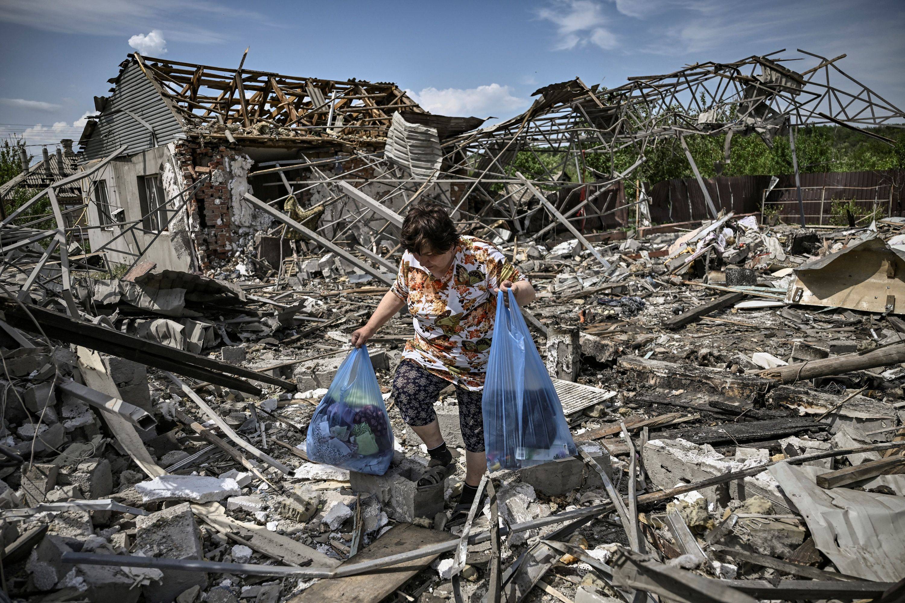A woman collects belongings in the ruble of their house after a strike destroyed three houses in the city of Slovyansk, Ukraine on Wednesday. | AFP-Jiji