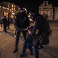Russian police officers arrest an anti-war protester in central Moscow on Feb. 25. Three months ago, President Vladimir Putin signed a law designed to silence war against Ukraine criticizers; now, at least 50 people face yearslong prison terms.  | SERGEY PONOMAREV / THE NEW YORK TIMES