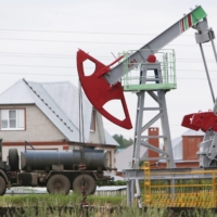 A fuel tanker drives past a pump jack near an oil field in Russia\'s Republic of Bashkortostan in July 2015. Not only is Russia\'s invasion of Ukraine affecting global food prices, but it also impacting the shipping of oil, a major cause of inflation. | REUTERS