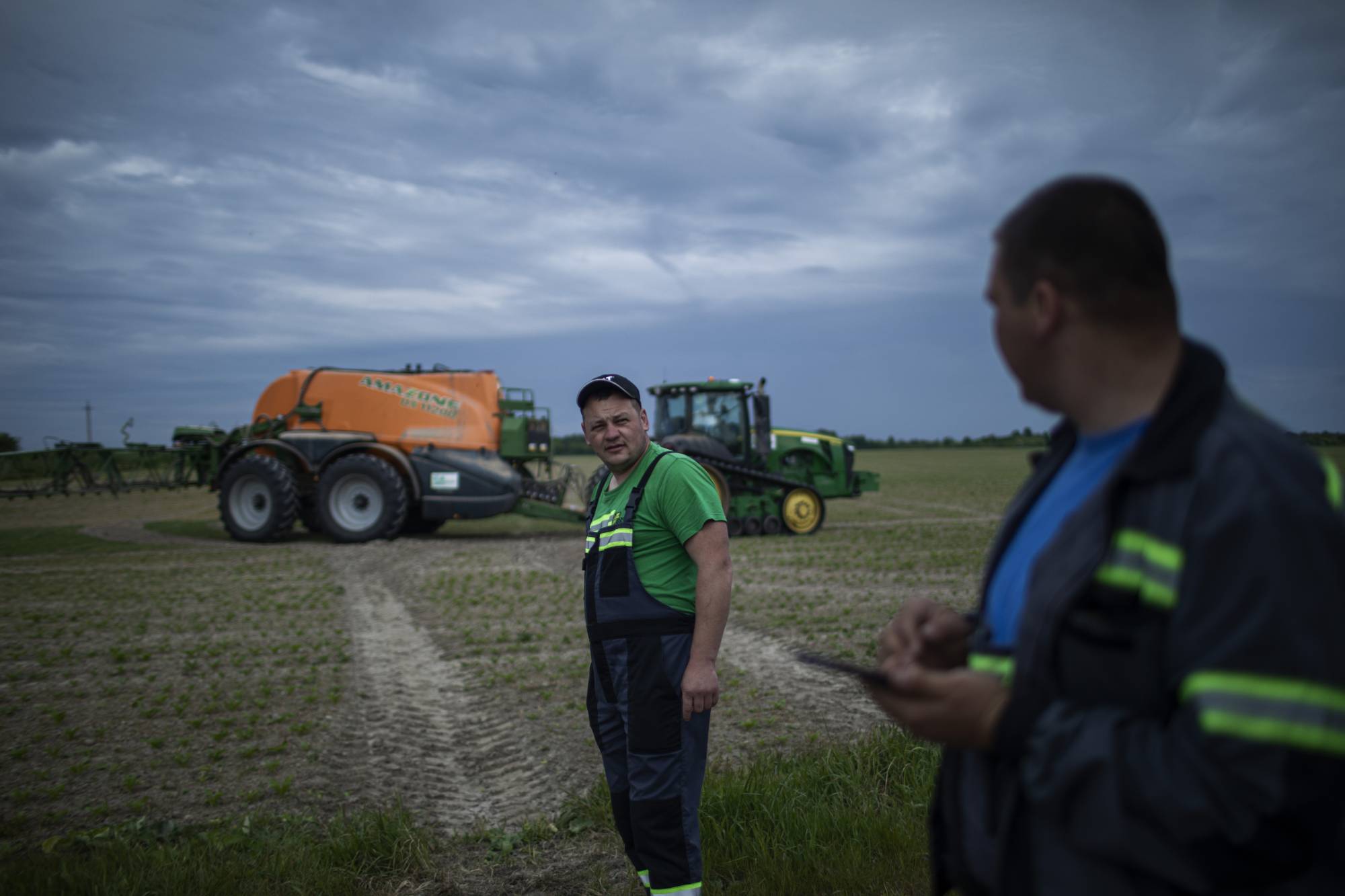Farmers work a field on the outskirts of Lviv, Ukraine, in May. | Diego Ibarra Sanchez / The New York Times