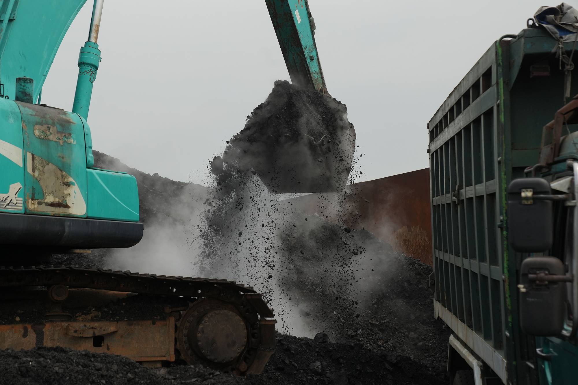 An excavator loads coal onto a dump truck at Cirebon Port in West Java, Indonesia, on May 11. | BLOOMBERG