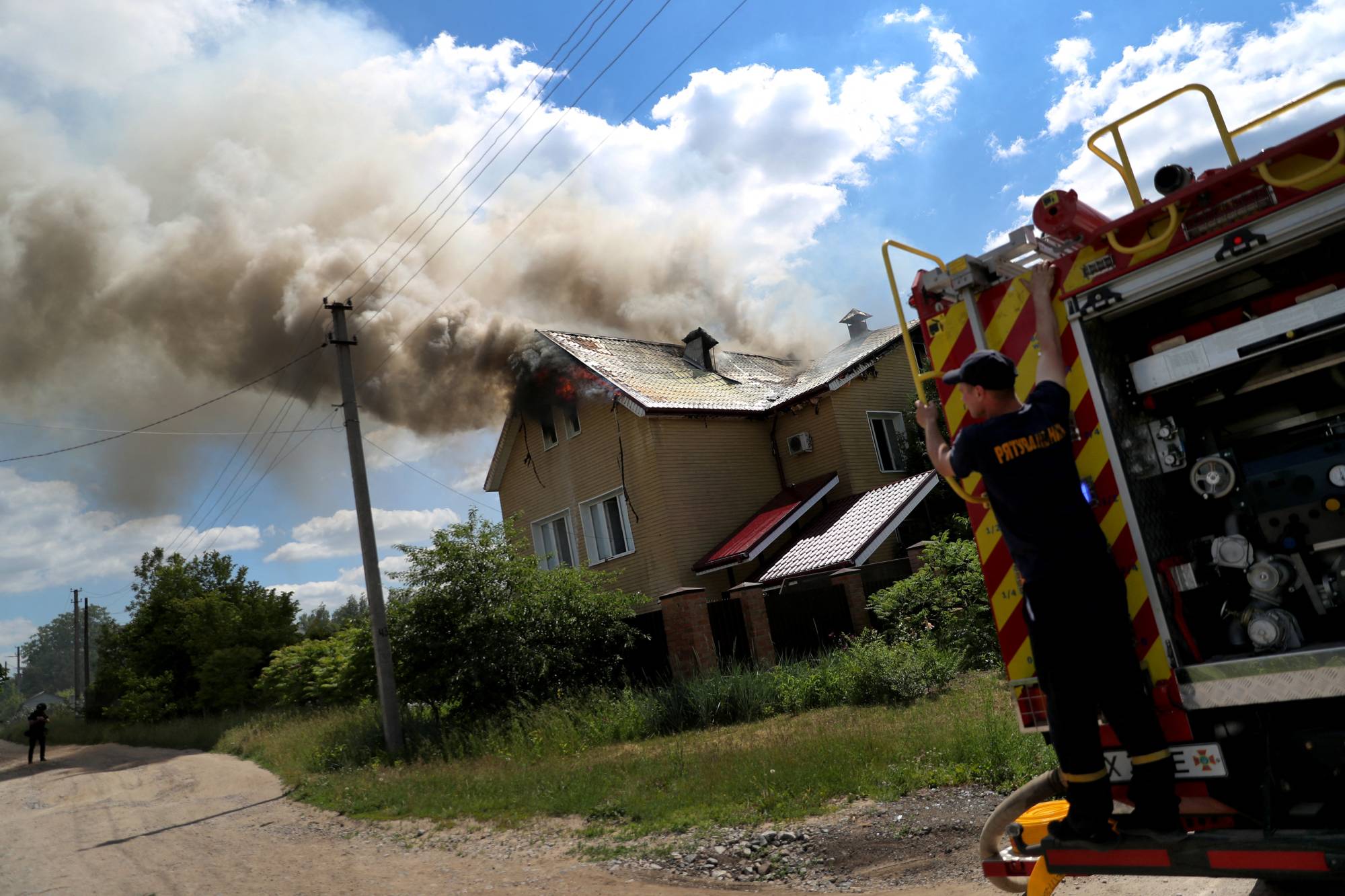 A house burns in a residential area in Kharkiv, Ukraine, following a military strike on Tuesday. | REUTERS