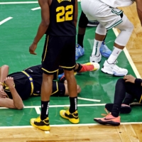 The Warriors\' Stephen Curry lies on the court after injuring his foot in Game 3 of the NBA FInals in Boston on Wednesday. | USA TODAY / VIA REUTERS