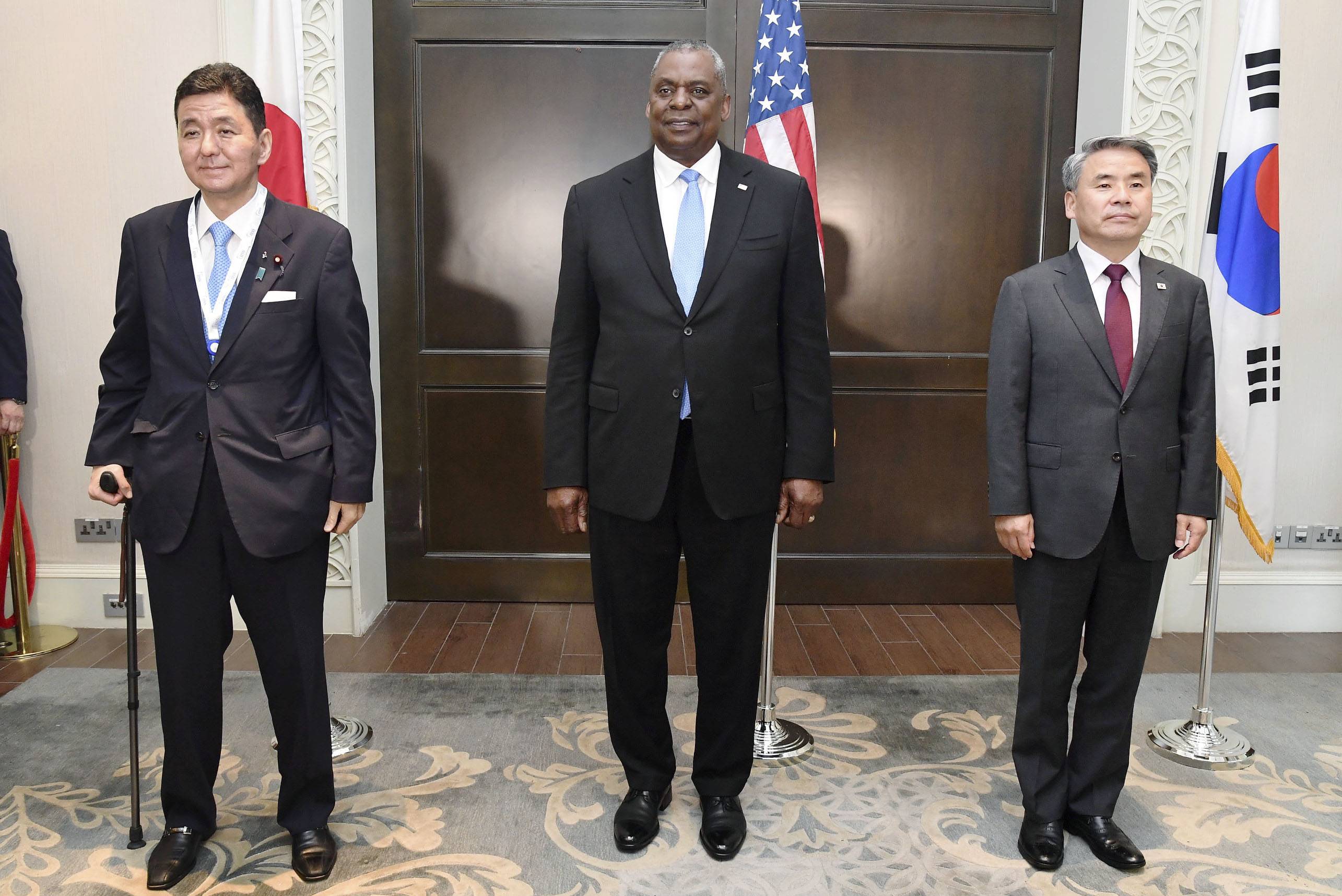 Japanese Defense Minister Nobuo Kishi, U.S. Defense Secretary Lloyd Austin and South Korean Defense Minister Lee Jong-sup pose for a picture during trilateral talks in Singapore on Saturday. | JAPANESE DEFENSE MINISTRY / VIA KYODO