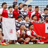 Japanese and Tongan players pose for a group photo after a charity match at Tokyo\'s Prince Chichibu Memorial Rugby Ground on Saturday. | KYODO