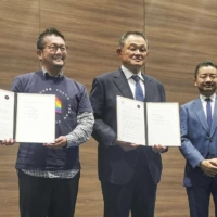 Pride House Tokyo head Gon Matsunaka (left) and Japanese Olympic Committee President Yasuhiro Yamashita (center) announce the signing of a framework agreement between the two groups on Monday. | KYODO