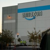 Workers outside an Amazon sort center under construction in San Diego, California, on March 9. | BLOOMBERG