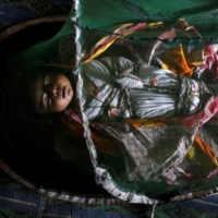 1-month-old Vamar Kumar, sleeps at home under a mosquito net. | REUTERS