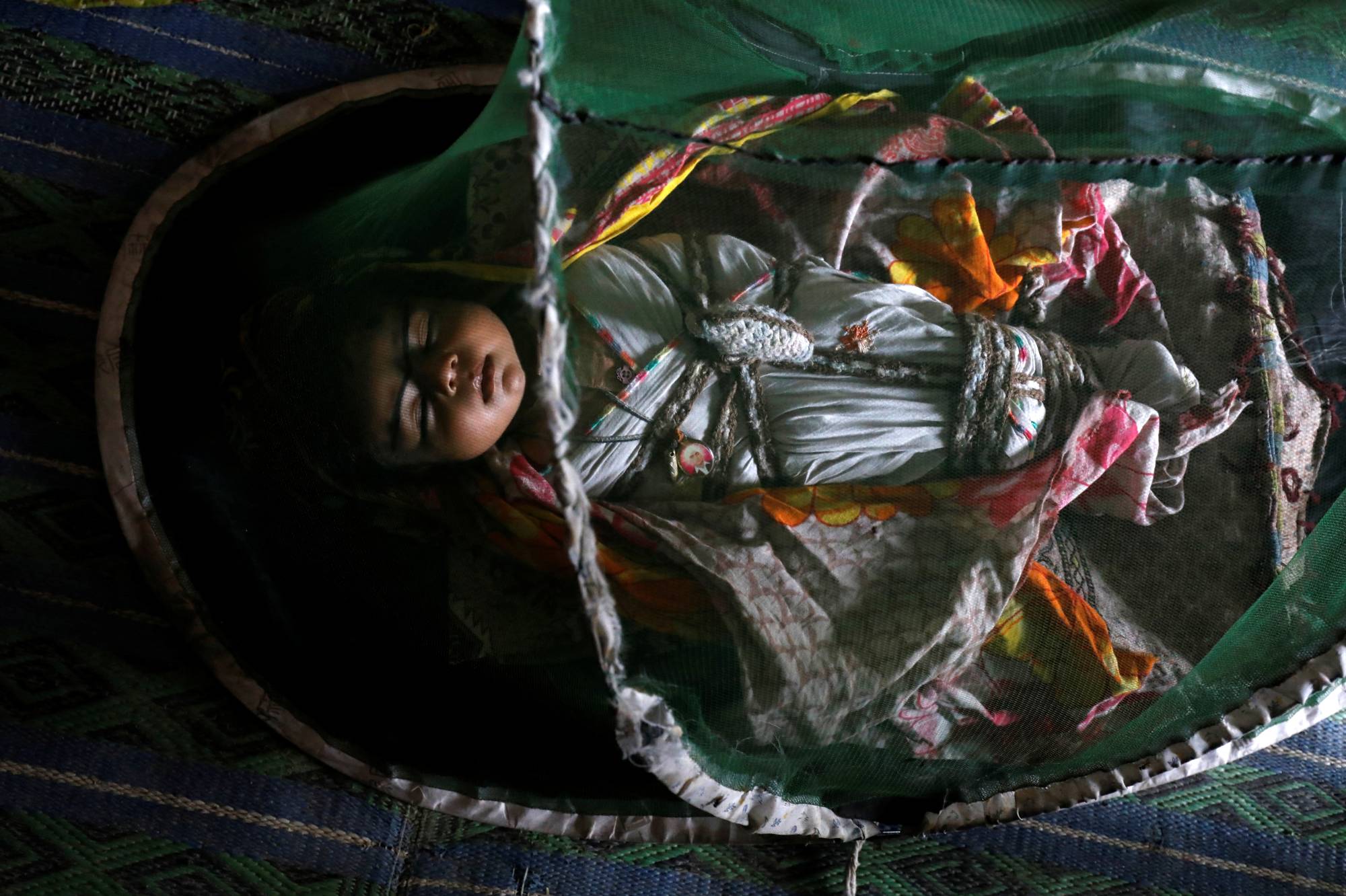 1-month-old Vamar Kumar, sleeps at home under a mosquito net. | REUTERS