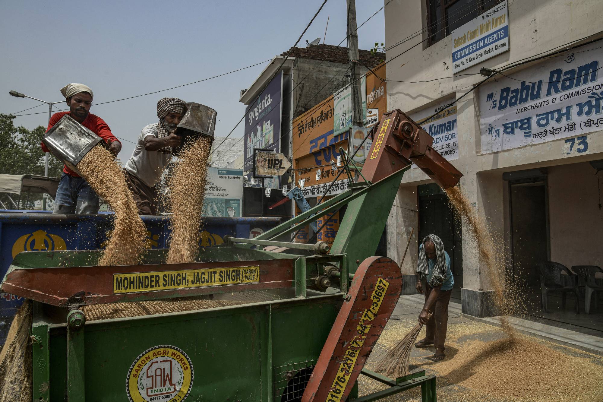Workers sort wheat grain in Khanna, India, on May 31. The wheat harvest in Punjab, the state that includes Khanna, is estimated to be down by about 15% this year. | Atul Loke / The New York Times