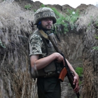 Ukrainian serviceman Petro walks in a trench on a position held by the Ukrainian army between southern cities of Mykolaiv and Kherson on Sunday. | AFP-JIJI