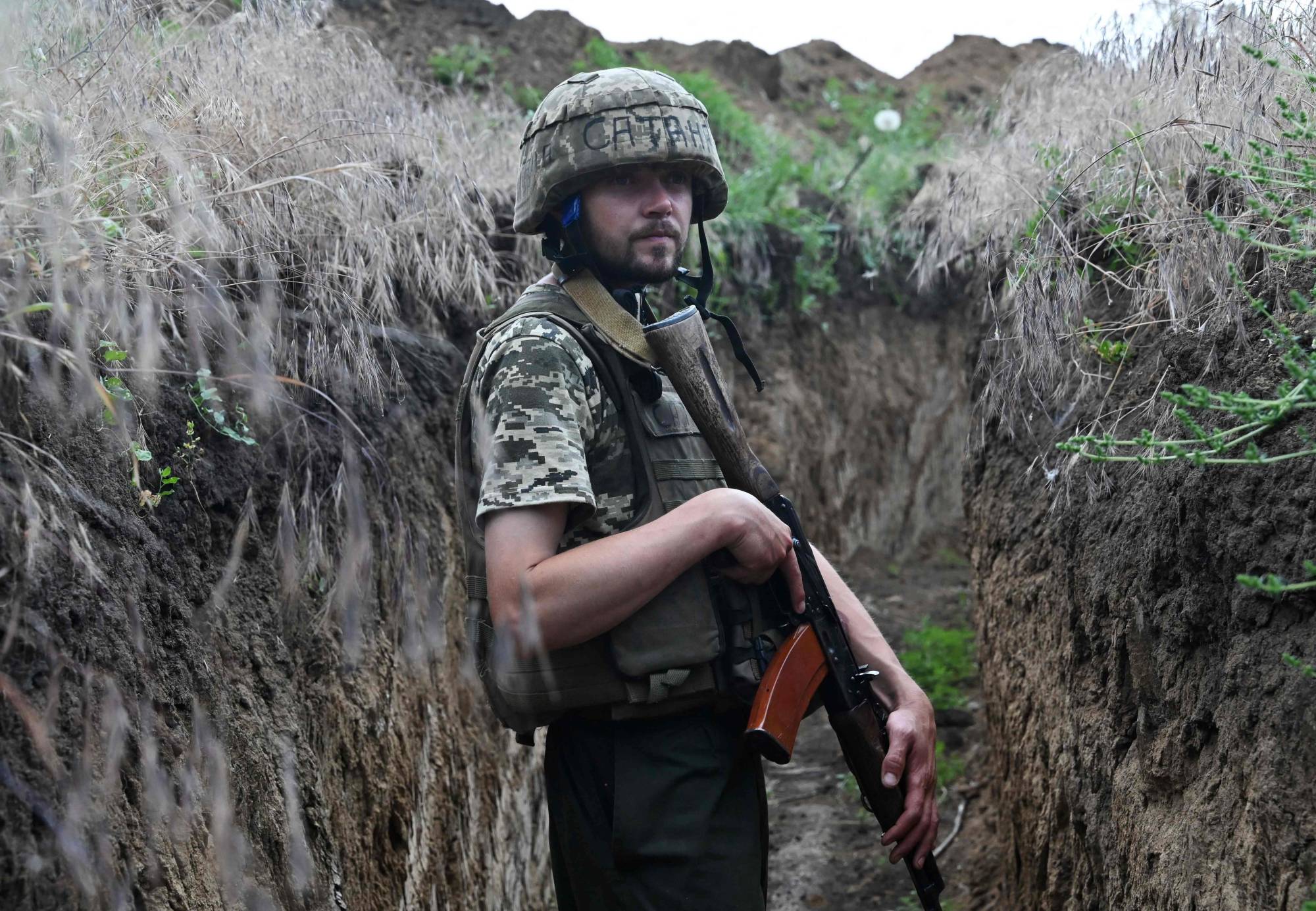 Ukrainian serviceman Petro walks in a trench on a position held by the Ukrainian army between southern cities of Mykolaiv and Kherson on Sunday. | AFP-JIJI